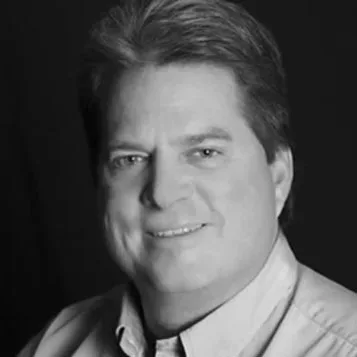 michael-headshot A black and white photo of a man smiling.